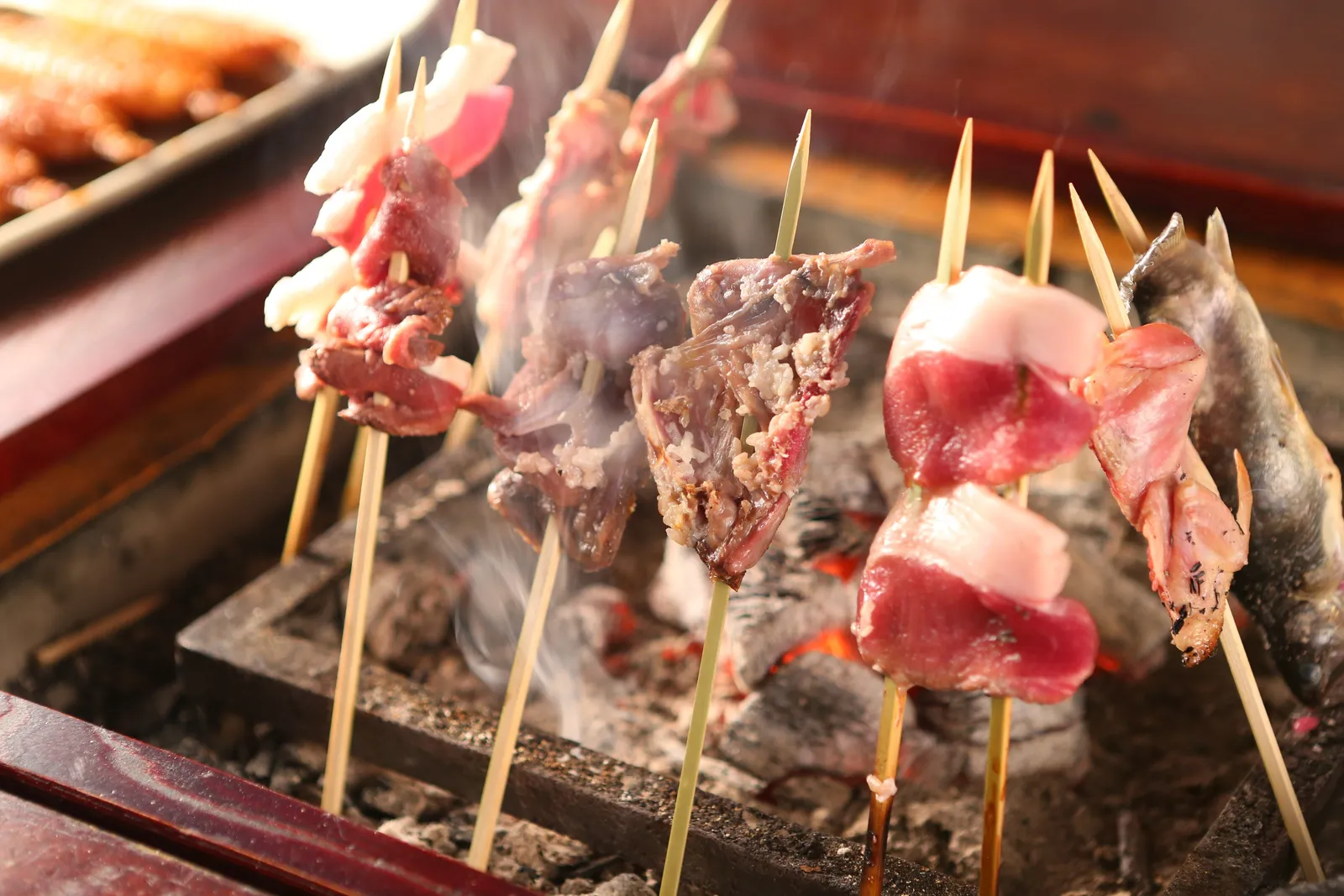 ジビエの串を炭火で焼くようす